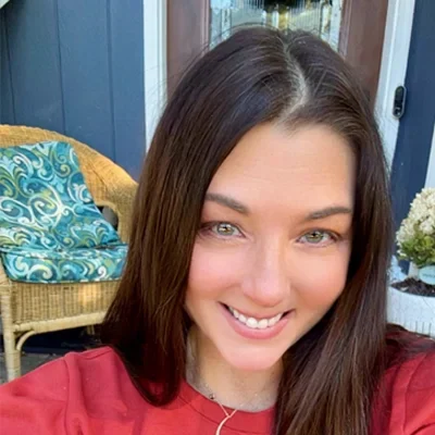 Lisa smiling at camera in red shirt